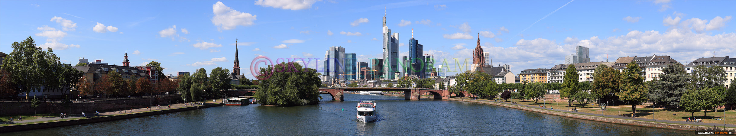 Panorama Bild - Die Frankfurter Skyline mit einem Ausflugsschiff von der Ignatz-Bubis-Brücke am Tag gesehen.