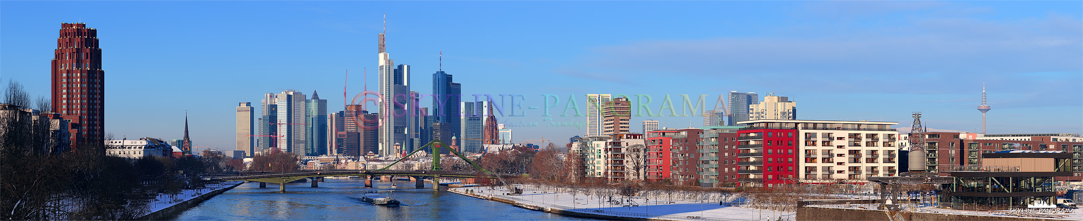 Skyline Bilder - Das Panorama zeigt den Blick von der Deutschherrnbrücke auf die verschneite Frankfurter Skyline mit den bekannten Hochhaustürmen.