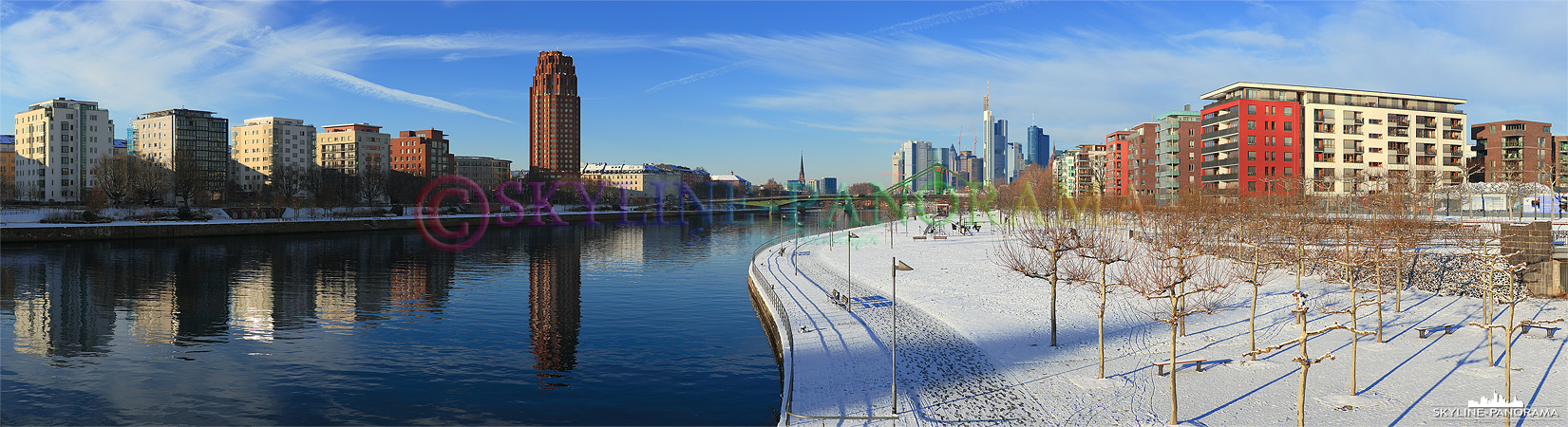 Winterbilder Frankfurt - Das verschneite Mainufer im Osten von Frankfurt mit Blick auf das Mainplaza und ein Teil der Frankfurter Skyline.