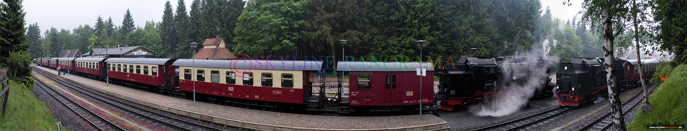 Bahnhof Schierke mit der einfahrenden Brockenbahn und einem stehenden Zug der auf die Weiterfahrt auf den Berg wartet. 