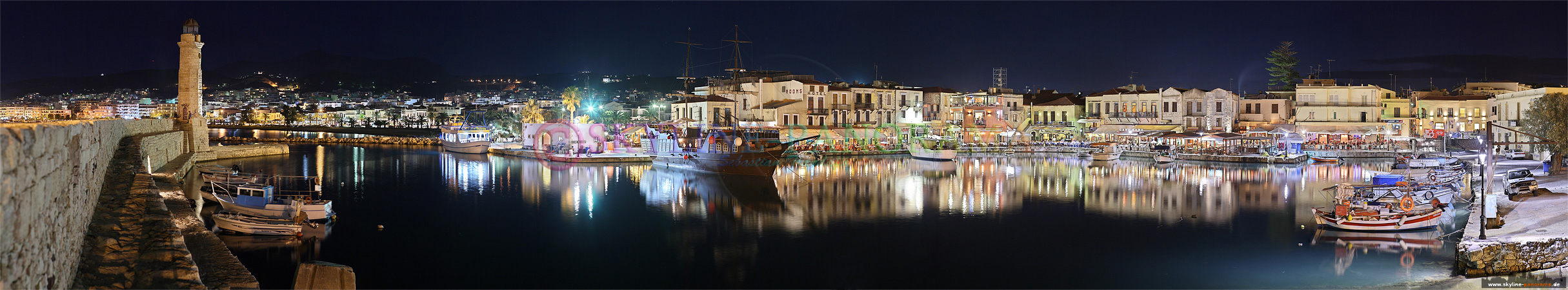 Panorama Rethymnon - der venezianische Hafen mit dem Leuchtturm von Rethymnon in einer Ansicht die abends entstanden ist und den Blick in das Hafenbecken zeigt.