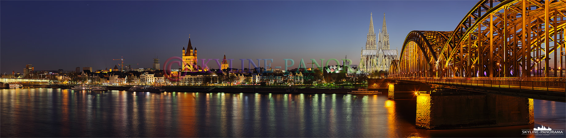 Köln Skyline - Panorama Bild vom Sockel der Hohenzollernbrücke in der Dämmerung. Entstanden ist das Skyline Bild im April 2010 als über Deutschland eine Aschewolke des Isländischen Vulkans Eyjafjallajökull den Flugverkehr behinderte und den Fotografen fotogene Sonnenuntergänge frei von Flugzeugen bescherte.