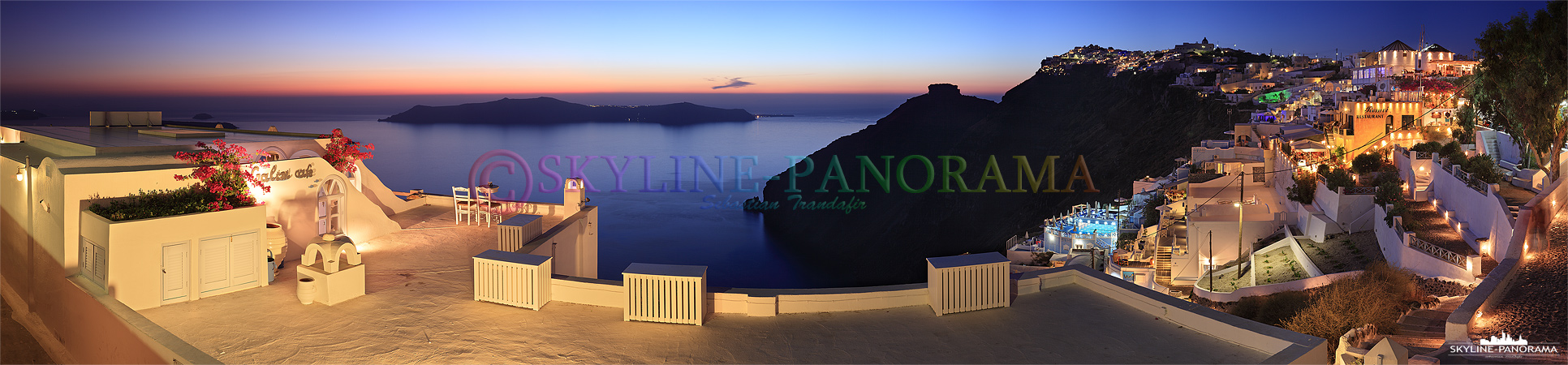 Ausblick von Firostefani auf die Caldera von Santorini kurz nach dem Sonnenuntergang, im Vordergrund ist die bekannte Terrasse des Galini Cafes zu sehen.