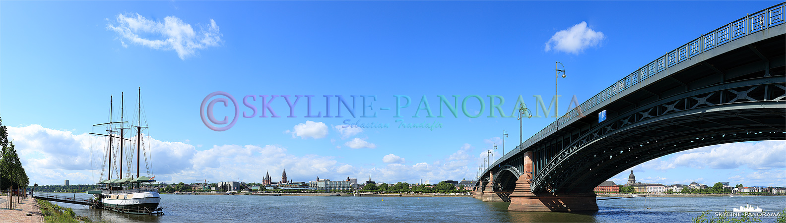 Skyline Bild - Stadtansicht der Mainzer Skyline mit dem Restaurantschiff „Pieter van Aemstel“ und der Theodor-Heuss-Brücke vom Rheinufer aus gesehen.