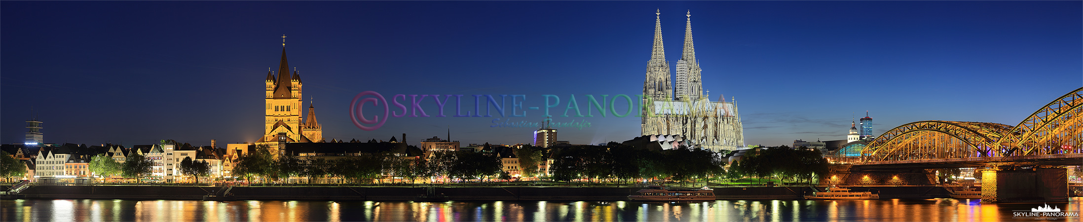 Panorama mit Kölner Dom - Die abendlich beleuchtete Skyline der Domstadt Köln - das Bild zeigt das Panorama vom Rheinufer aus auf die Kölner Altstadt mit der Kirche Sankt Martin und dem Kölner Dom zur einbrechenden Nacht. 