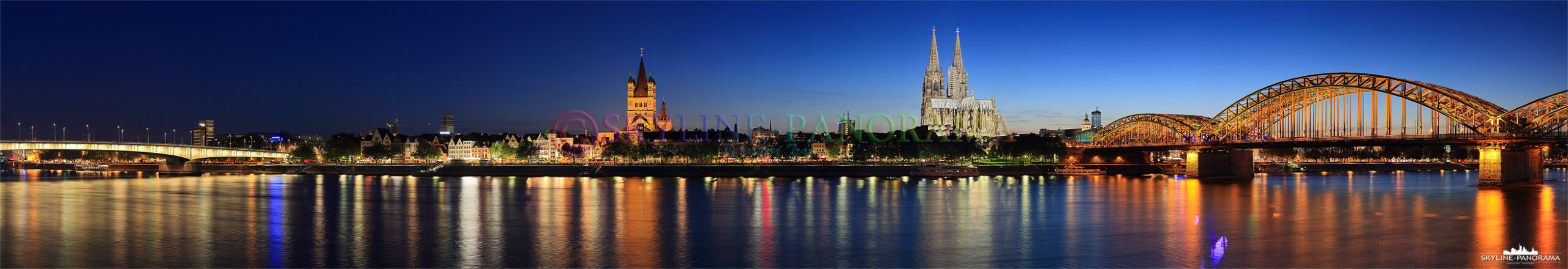 Köln Skyline Panorama mit Kölner Dom - Diese Aufnahme zeigt das Köln Panorama zur Blauen Stunde, der Blick geht von der abendlich beleuchteten Deutzerbrücke über die Rheinterrassen, der Kirche Sankt Martin zum Wahrzeichen der Stadt, dem Kölner Dom und weiter zur hell erleuchteten Hohenzollernbrücke - das Panorama entstand im Sommer 2012 am Rheinufer in Köln Deutz.