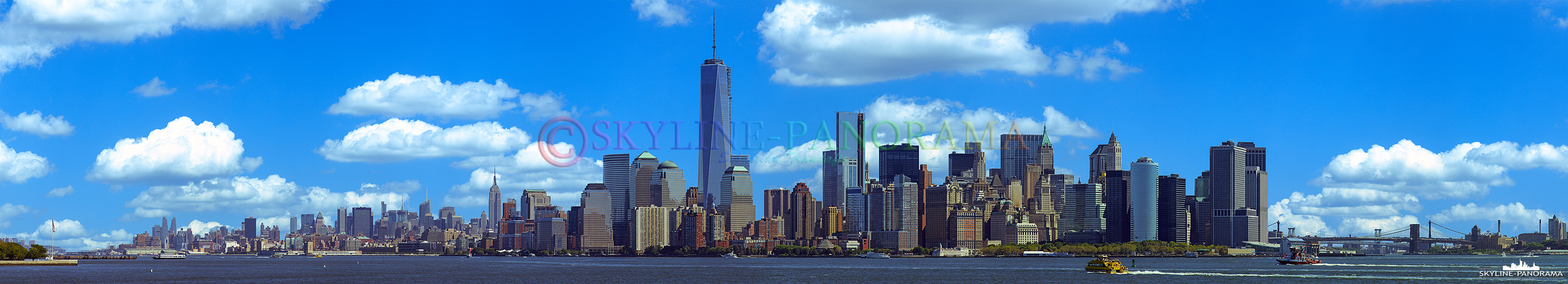 Manhattan am Tag - Blick von Liberty Island auf die Südspitze von Manhattan mit dem One World Trade Center und dem Empire State Building, die beiden Wolkenkratzer gehören zu den bekanntesten Wahrzeichen von New York City.