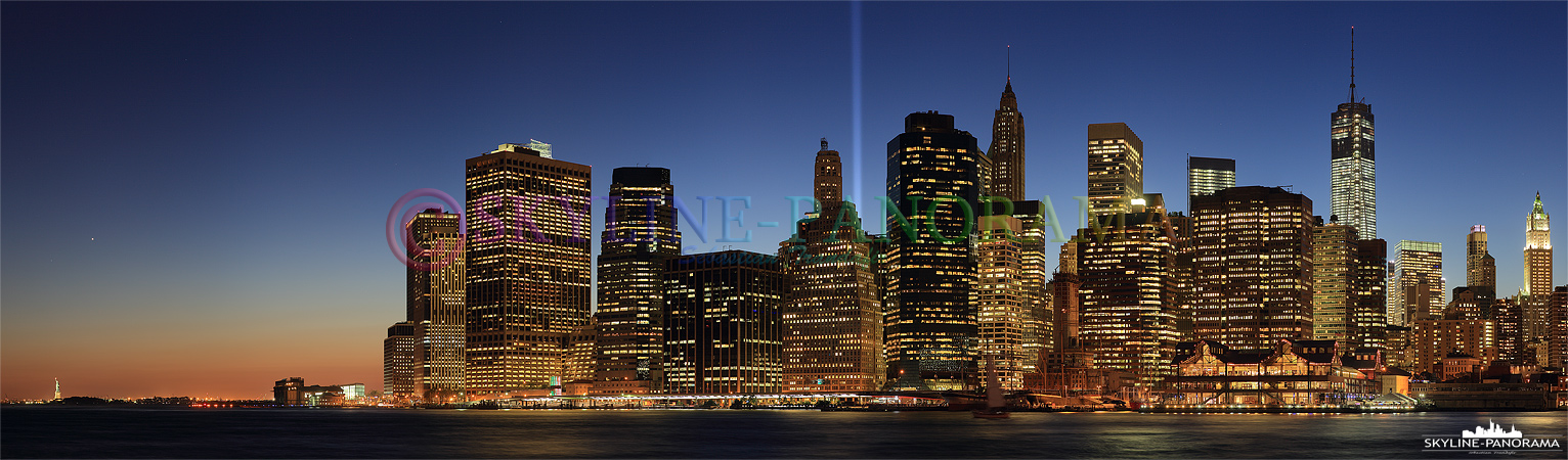 Skyline New York - Das Skyline Panorama der Südspitze von Manhattan vom Brooklyn Bridge Park aus gesehen, es zeigt den abendlichen Blick von der Freiheitsstatue bis zum fast fertig gestellten Freedom Tower