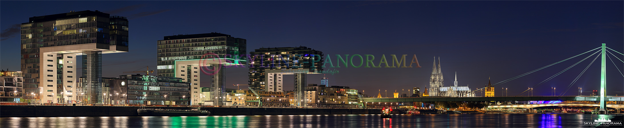 Köln Panorama - Die drei Kranhäuser im Rheinauhafen zusammen mit dem Kölner Dom zur Nacht von den Poller Wiesen aus gesehen.