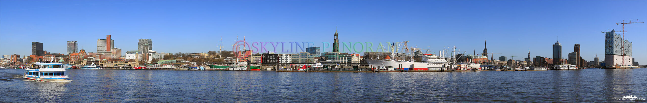 Bilder aus Hamburg - Die Hamburger Skyline mit den Landungsbrücken, dem Michel, der Speicherstadt und der Hafencity vom Elbufer aus gesehen.