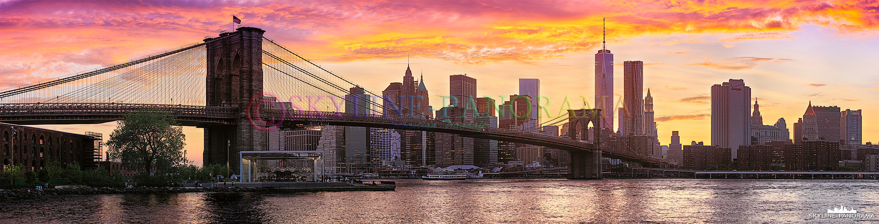 Manhattan Panorama - Die Skyline von Downtown Manhattan mit dem höchsten Wolkenkratzer New Yorks, dem One World Trade Center 1 und der historischen Brooklyn Bridge im Vordergrund kurz vor dem Sonnenuntergang vom Empire Fulton Ferry State Park gesehen. 