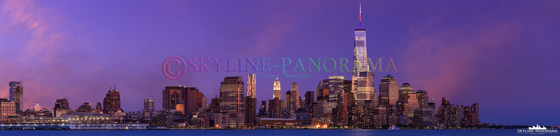 Panorama USA - Die New Yorker Skyline am Abend mit den hell erleuchteten Wolkenkratzern und dem alles überragenden One World Trade Center 1, dessen Antenne zu diesem Zeitpunkt in den US Nationalfarben Weiß-Rot-Blau angeleuchtet wurde. 