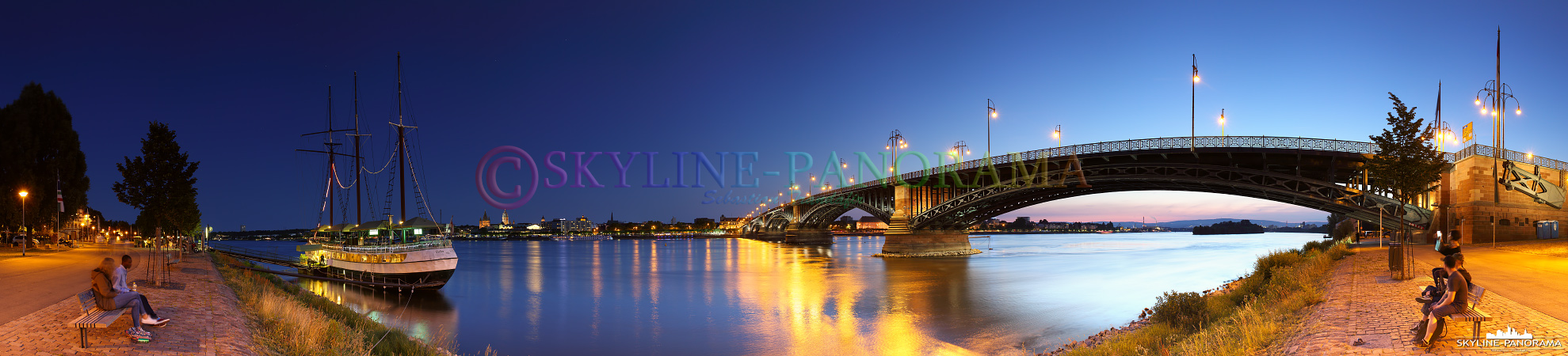 Abendlicher Blick vom Rheinufer in Mainz-Kastel mit der Theodor-Heuss-Brücke und dem Restaurantschiff Pieter van Aemstel auf die Landeshauptstadt Mainz. 