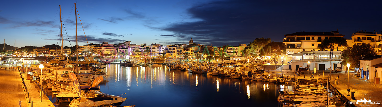 Balearen Mallorca - Dieses Panorama zeigt den abendlichen Blick in den Yachthafen von Cala Ratjada auf der beliebten Ferieninsel Mallorca.