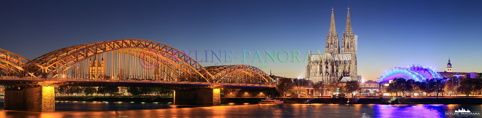 Bilder von Köln - Das Panorama auf Köln zur Dämmerung mit der Hohenzollernbrücke und dem Kölner Dom vom Kennedy Ufer aus gesehen.