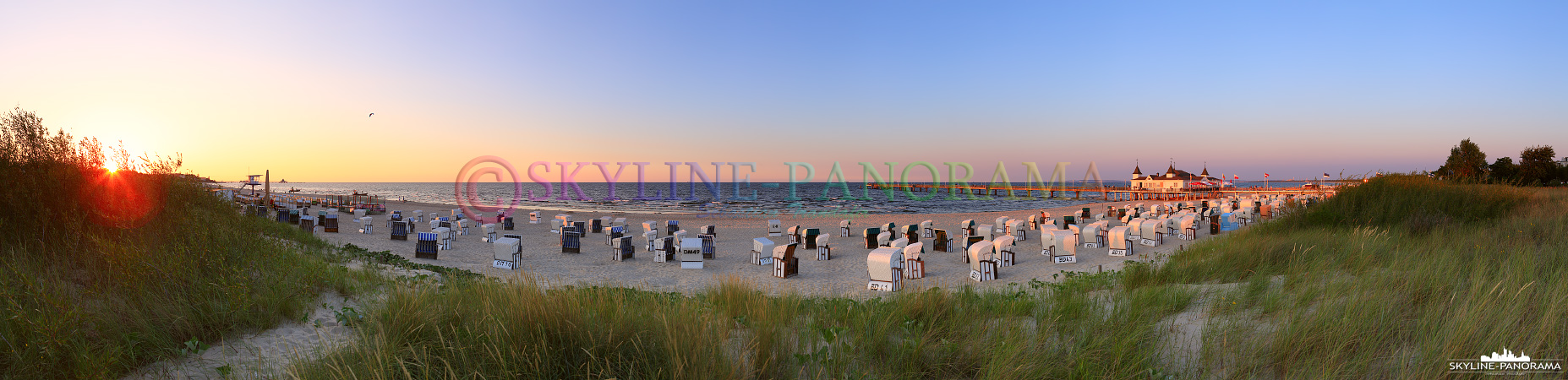 Bilder Usedom - Der abendliche Strand von Ahlbeck mit der historischen Seebrücke und den bekannten Strandkörben wurde hier zum Sonnenuntergang, mit dem letzten Licht des Tages, als Panorama fotografiert. 