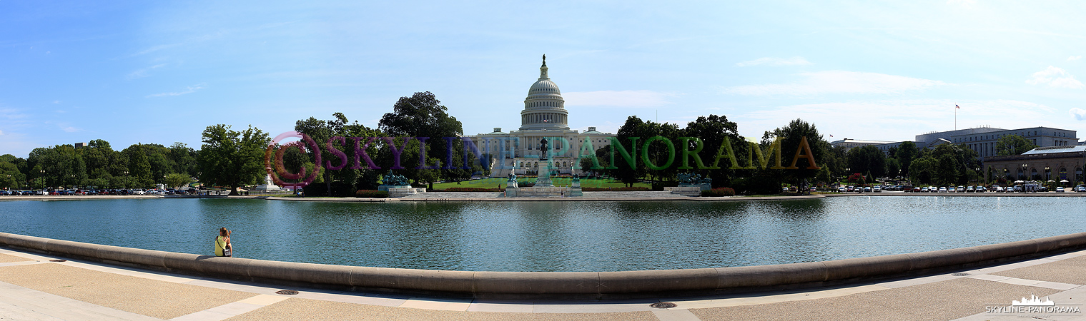 Sehenswürdigkeiten in Washington - Das U.S. Capitol mit dem Capitol Reflecting Pool im Vordergrund als Panorama am Tag. 