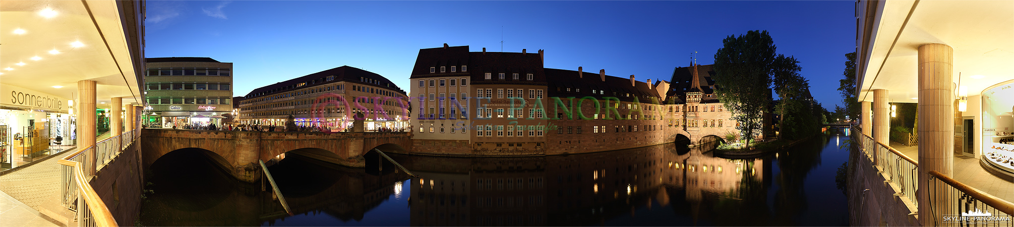 Sehenswürdigkeiten Nürnberg - Das abendliche Panorama auf eine der bekanntesten Sehenswürdigkeiten von Nürnberg - das beleuchtete Heilig Geist Spital mit der Spital-Apotheke an der Pegnitz gelegen. 