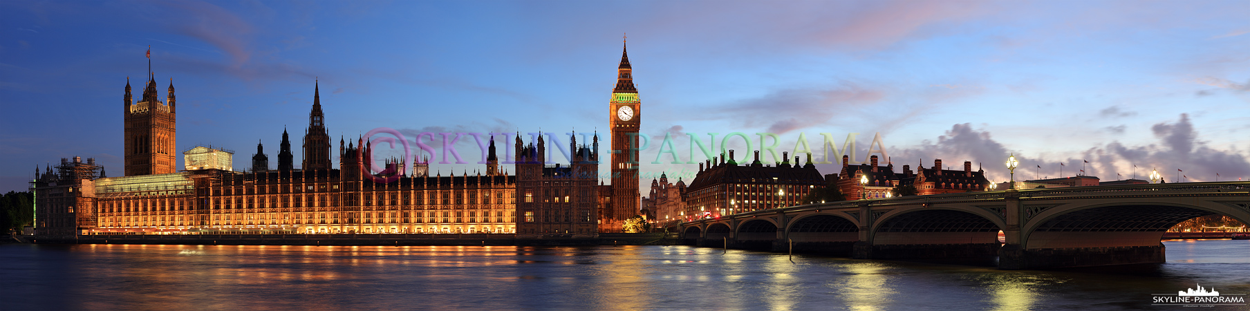 Bilder aus Großbritannien – Der abendlich beleuchtete Palace of Westminster und Big Ben vom Ufer der Themse gesehen.