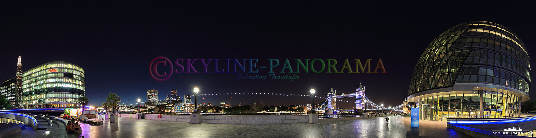 London Panorama – Abendlicher Blick von der The Queen´s Walk genannten Themse Promenade auf die beleuchtete Tower Bridge und die City Hall von London.