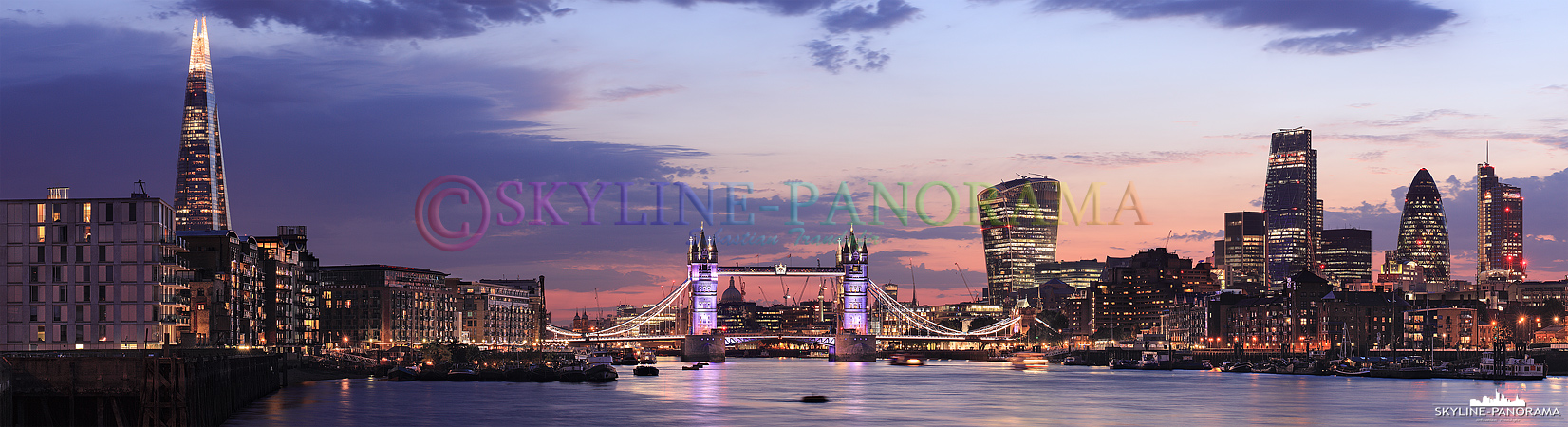 Panorama London by night - Die abendliche Skyline von London mit der historischen Tower Bridge und den futuristischen Wolkenkratzern der englischen Hauptstadt als Panorama.