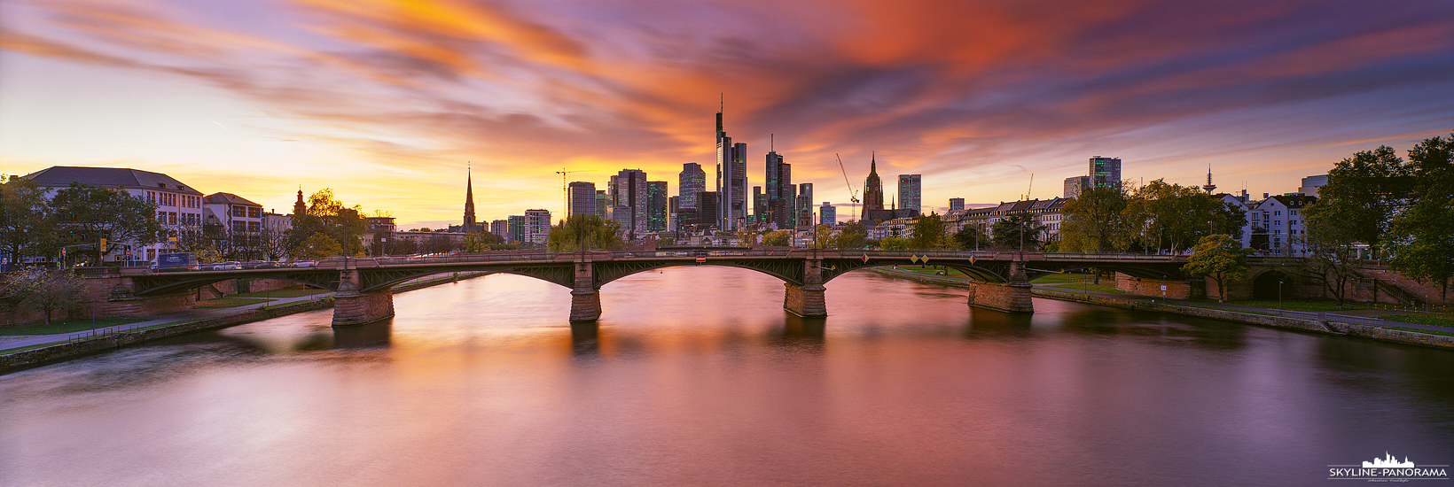 6x17 Panorama Frankfurt - Die Skyline mit dem ins Rot getauchten und hell erleuchteten Abendhimmel. Der Blick geht von der Flößerbrücke aus zur Skyline von FFM.