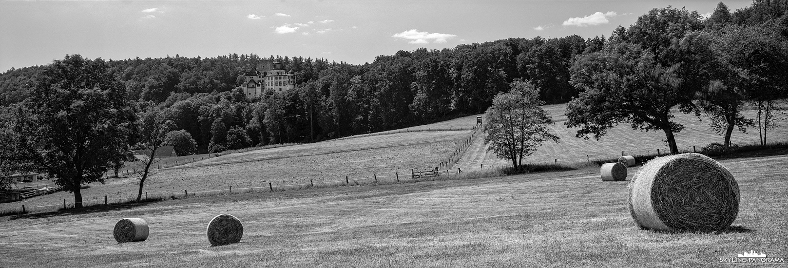 6x17 Panorama - Die Burg Hohlenfels bei Hahnstätten im Rhein-Lahn-Kreis mit einem abgeernteten Getreidefeld und ein paar aufgerollten Heuballen im Vordergund.