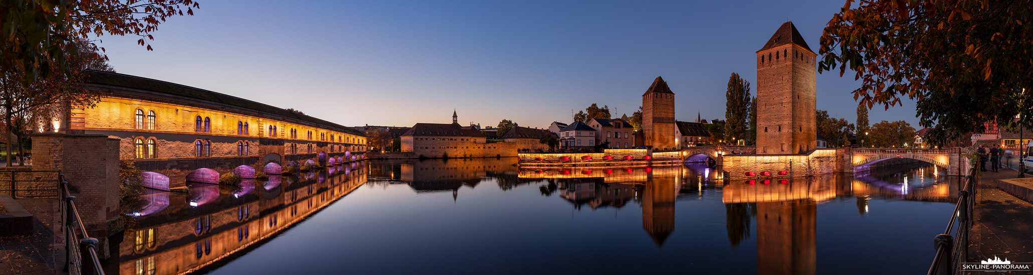 Panorama Frankreich - In der Dämmerung unterwegs in der Altstadt von Straßburg, auf diesem Panorama sind die wuchtigen Wehrtürme der ehemaligen Stadtbefestigung mit den Gedeckten Brücken am Fluss Ill zu sehen.