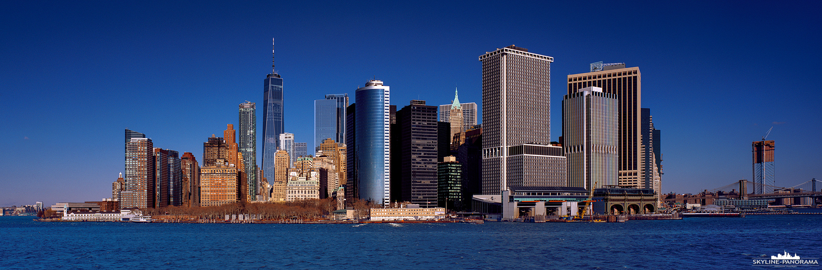 New York Panorama - Die Skyline der Millionenmetropole New York mit dem Blick von der Staten Island Ferry auf Lower Manhattan. Die Fährverbindung von Manhattan nach Staten Island ist kostenlos,  da sie einen wunderbaren Blick auf die Skyline von New York bietet und zusätzlich direkt an der Freiheitsstatue vorbei fährt, ist der kurze Abstecher nach Staten Island sehr zu empfehlen.