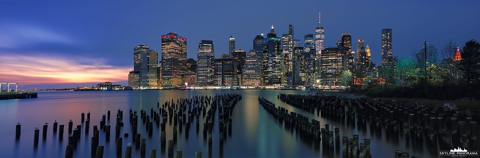 New York Panorama - Blick auf die Skyline von Downtown Manhattan gesehen vom Brooklyn Bridge Park aus, im Vordergrund sind die Überreste des Old Pier 1 zu sehen.