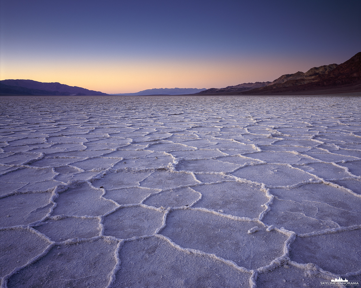 Death Valley als Largeformat - Bekanntermaßen ist der Death Valley Nationalpark, mit etwas über 85 Meter unter dem Meeresspiegel, der am tiefsten gelegene Ort der westlichen Hemisphäre. Der exakt tiefste Punkt liegt allerdings einige Kilometer vom Badwater Basin entfernt und verändert durch geologische Prozesse ständig seine genaue Position. Das hier gezeigte Bild entstand zum Sonnenaufgang, es zeigt die beeindruckenden sechseckigen Strukturen aus Salz, für die Badwater Basin bekannt ist.