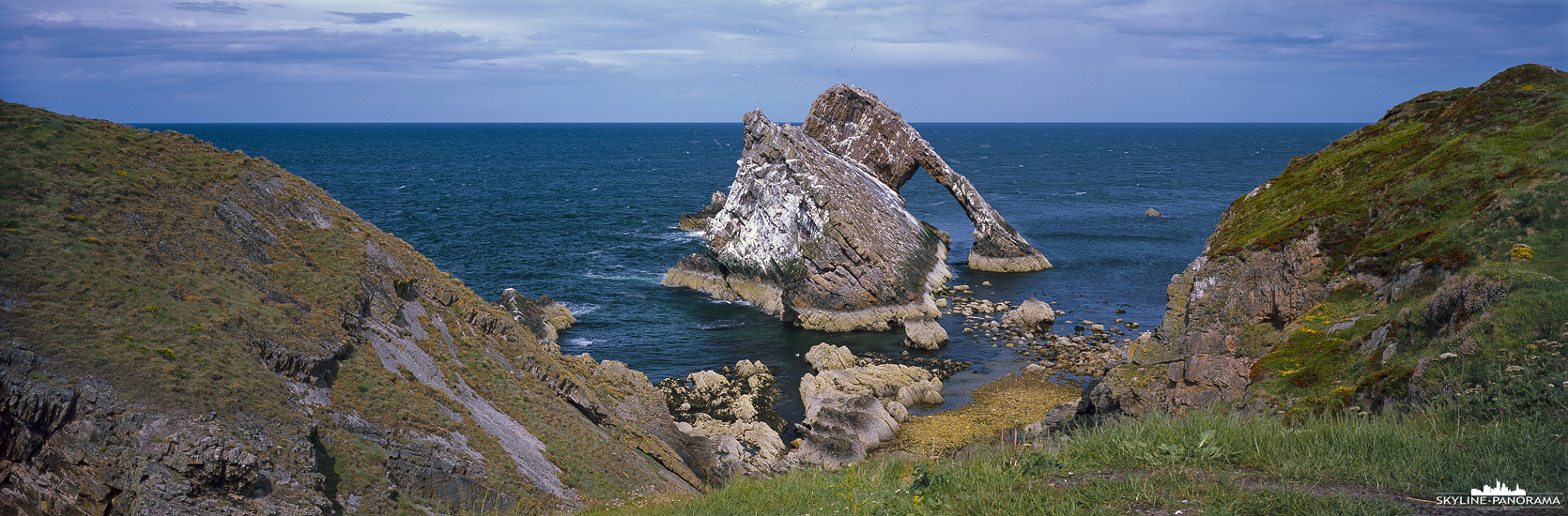 Panorama Schottland - Überlieferungen zu folge trägt der beeindruckende Felsen seinen Namen, weil er aussieht wie die Spitze eines Geigenbogens. Der Bow Fiddle Rock ist ein natürlicher Meeresbogen in der Nähe des Ortes Portknockie an der Nordostküste Schottlands, man kann ihn bequem in einem kurzen Spaziergang vom Ort erreichen.
