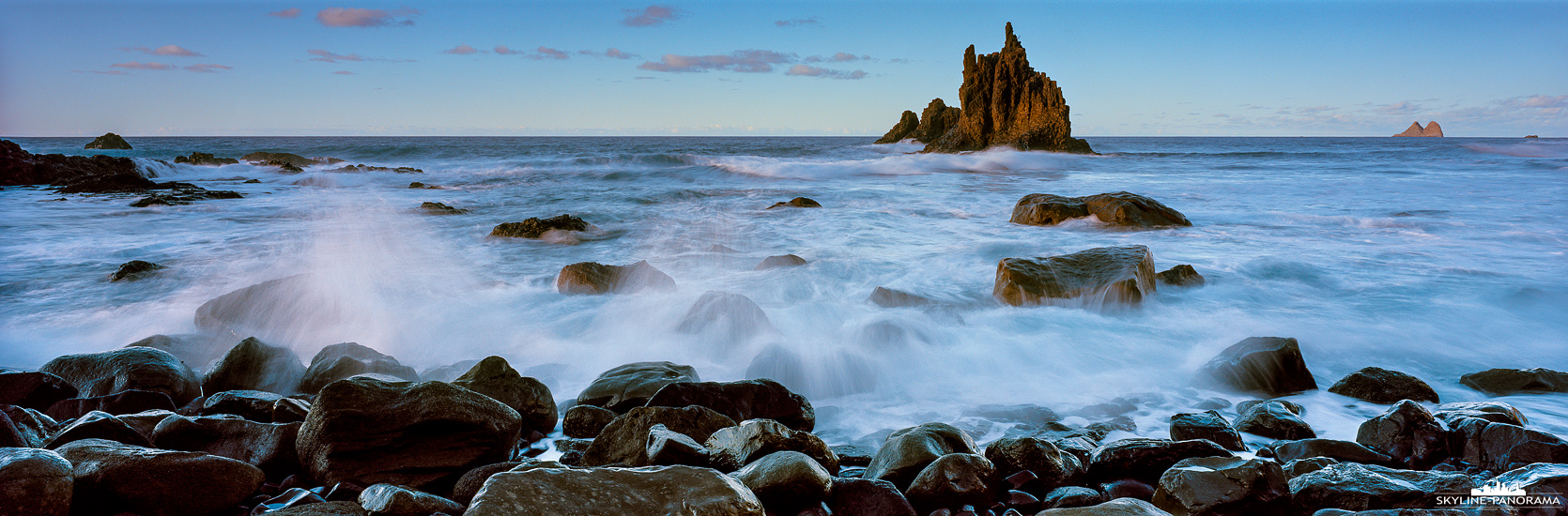 Fotolocations auf Teneriffa - Der Playa de Benijo zählt unter Fotografen zu den beliebtesten Fotospots auf der Kanareninsel Teneriffa, dabei ist der malerische Ort im Anaga Gebirge nicht nur bei Landschaftsfotografen beliebt, auch wird er oft für Modelshootings als Kulisse gewählt. Hier zu sehen ist die markante Felsnadel am Playa de Benijo im Schein der untergehenden Sonne, die See ist rau und die Wellen peitschen mit voller Wucht gegen die großen Brocken am Strand.